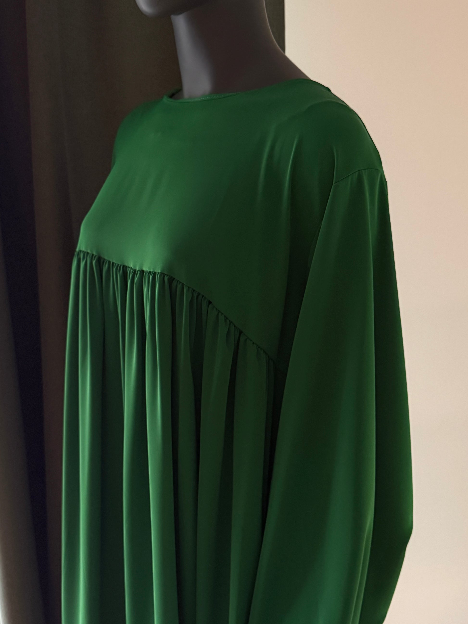 Green dress on a mannequin against a neutral background